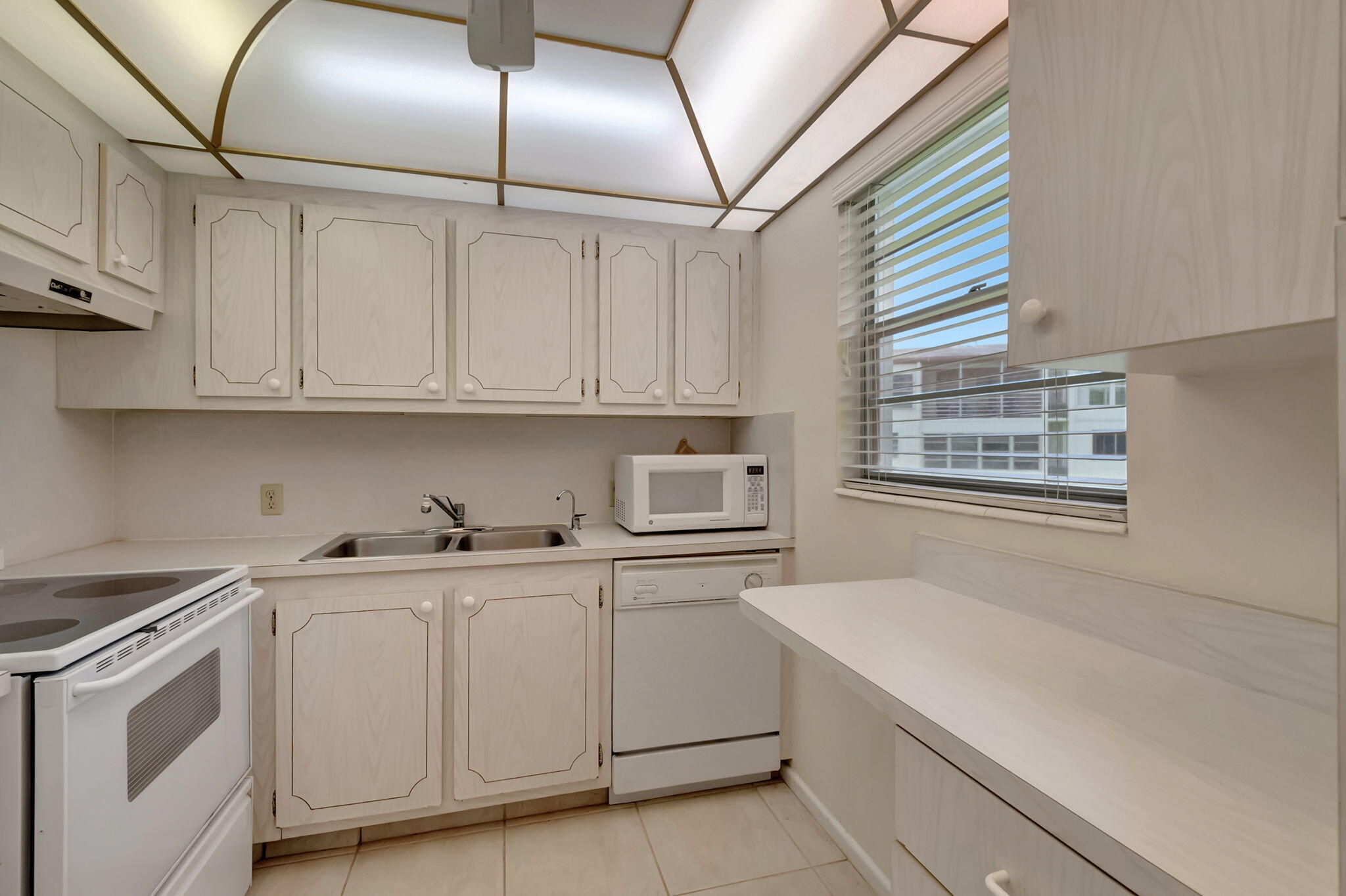 28 Fanshaw A Boca Raton, FL 33434 - Photo 8 of 63 a kitchen with white cabinets and white appliances