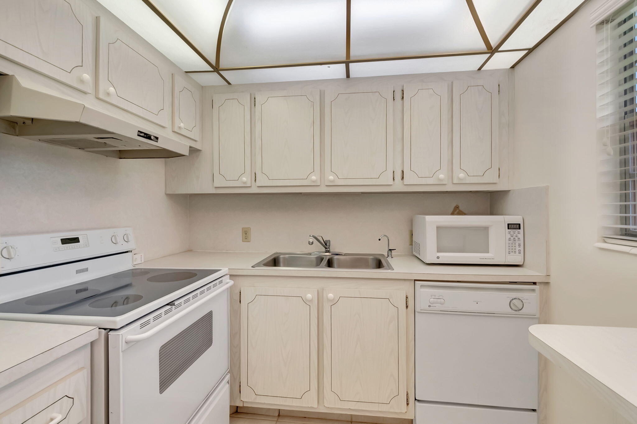 28 Fanshaw A Boca Raton, FL 33434 - Photo 9 of 63 a kitchen with white cabinets and white appliances