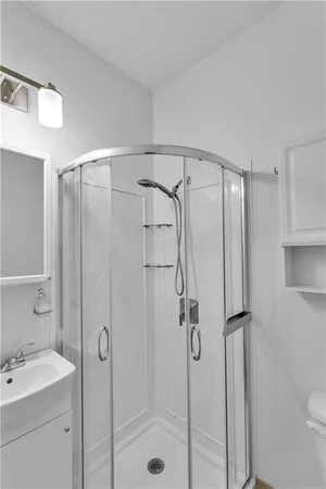 a bathroom with a shower sink vanity and toilet