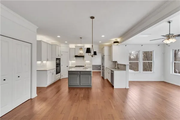 a view of a kitchen with wooden floor and windows