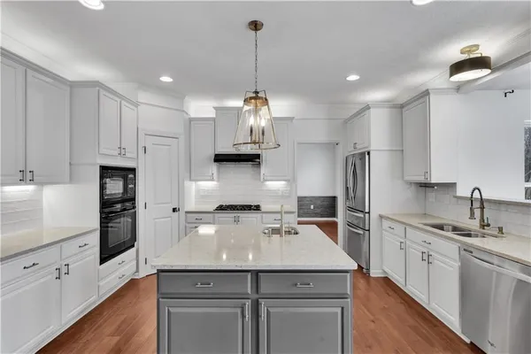 a kitchen with kitchen island white cabinets and stainless steel appliances