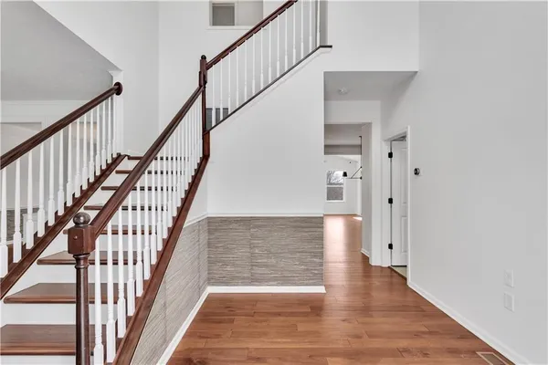 a view of staircase with wooden floor and white walls