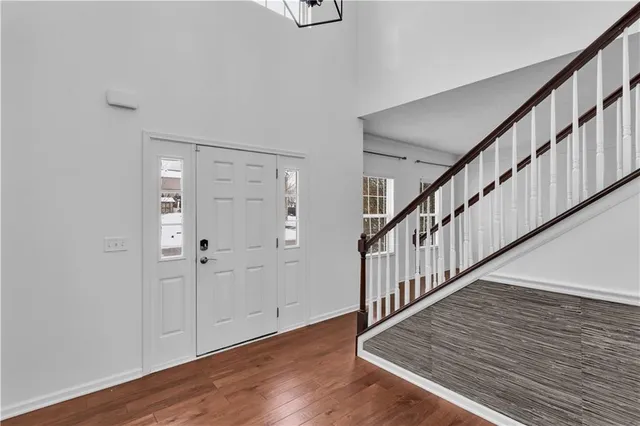 a view of staircase with wooden floor and a chandelier