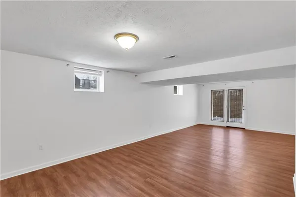 a view of empty room with wooden floor
