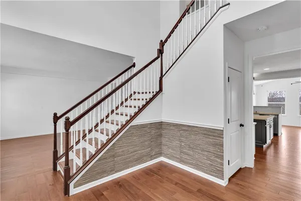 a view of staircase with wooden floor and a chandelier