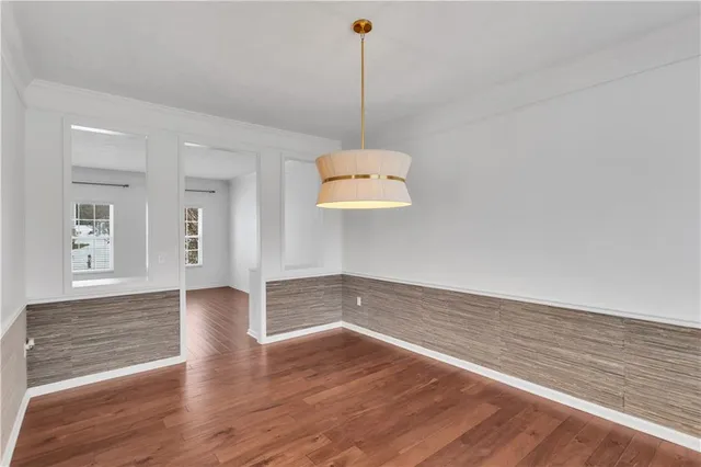 a kitchen with stainless steel appliances granite countertop a sink a stove a refrigerator and white cabinets with wooden floor