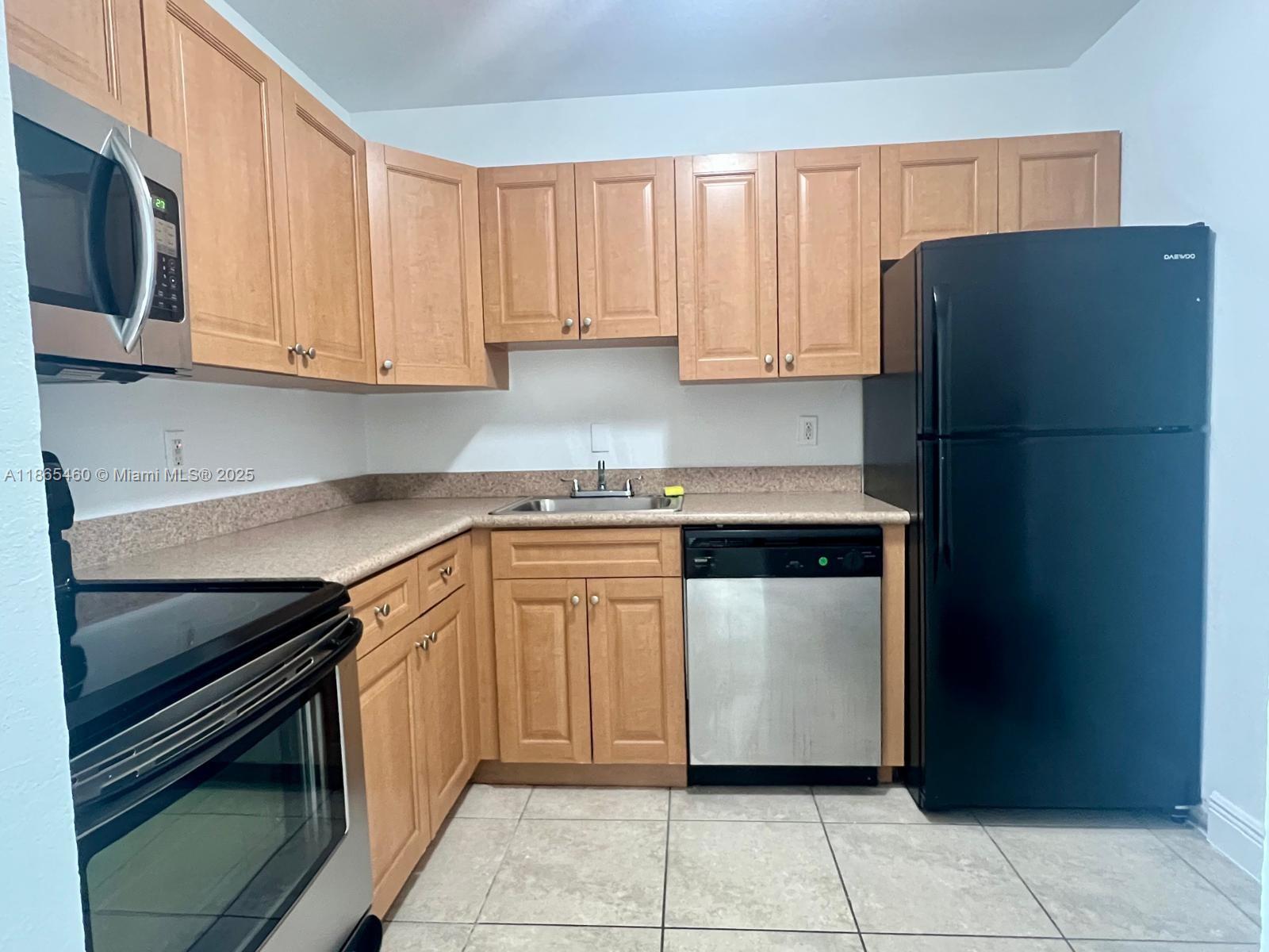 4810 Northwest 79th Avenue, Unit 305 Doral, FL 33166 - Photo 11 of 28 a kitchen with stainless steel appliances granite countertop a refrigerator and a stove top oven