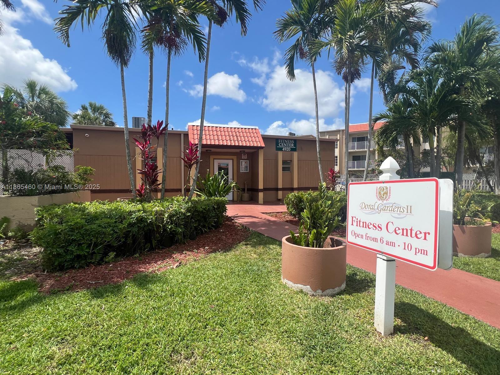 4810 Northwest 79th Avenue, Unit 305 Doral, FL 33166 - Photo 21 of 28 a view of a park that has a sign board and palm trees