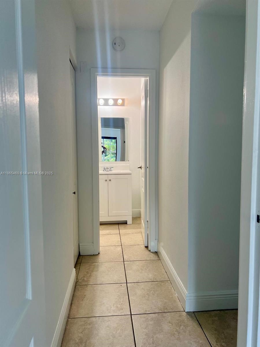4810 Northwest 79th Avenue, Unit 305 Doral, FL 33166 - Photo 6 of 28 a view of a hallway and a bathroom with mirror