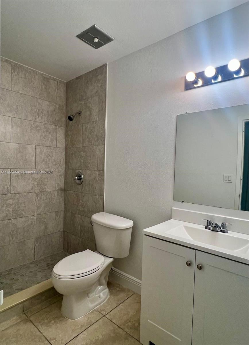 4810 Northwest 79th Avenue, Unit 305 Doral, FL 33166 - Photo 7 of 28 a bathroom with a toilet a sink a mirror and shower