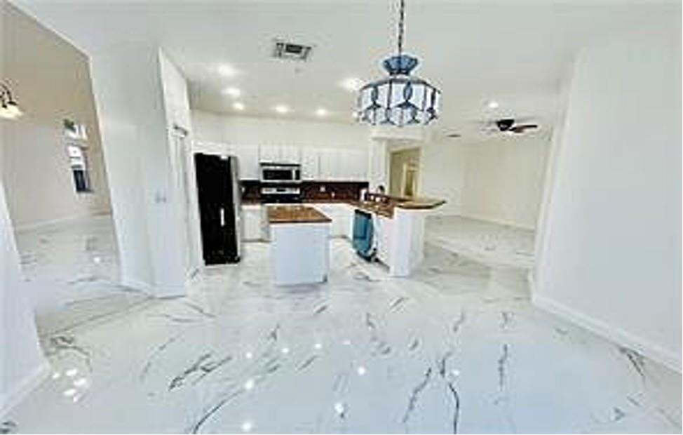11041 Harbour Springs Circle Boca Raton, FL 33428 - Photo 4 of 15 a view of a dining room with furniture a chandelier and kitchen view