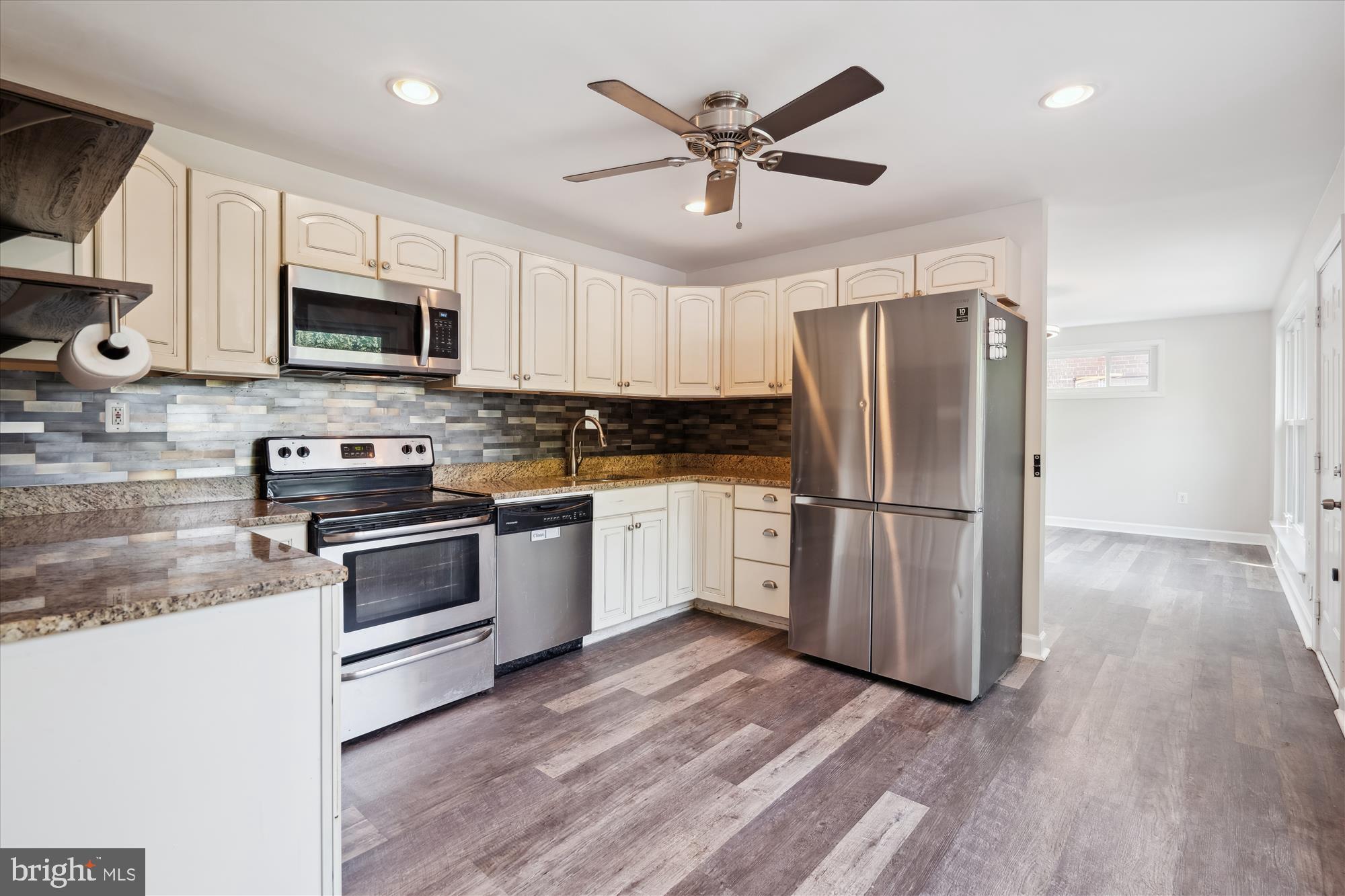 12812 Crisfield Road Silver Spring, MD 20906 - Photo 17 of 83 a kitchen with granite countertop a refrigerator a stove top oven a sink and cabinets