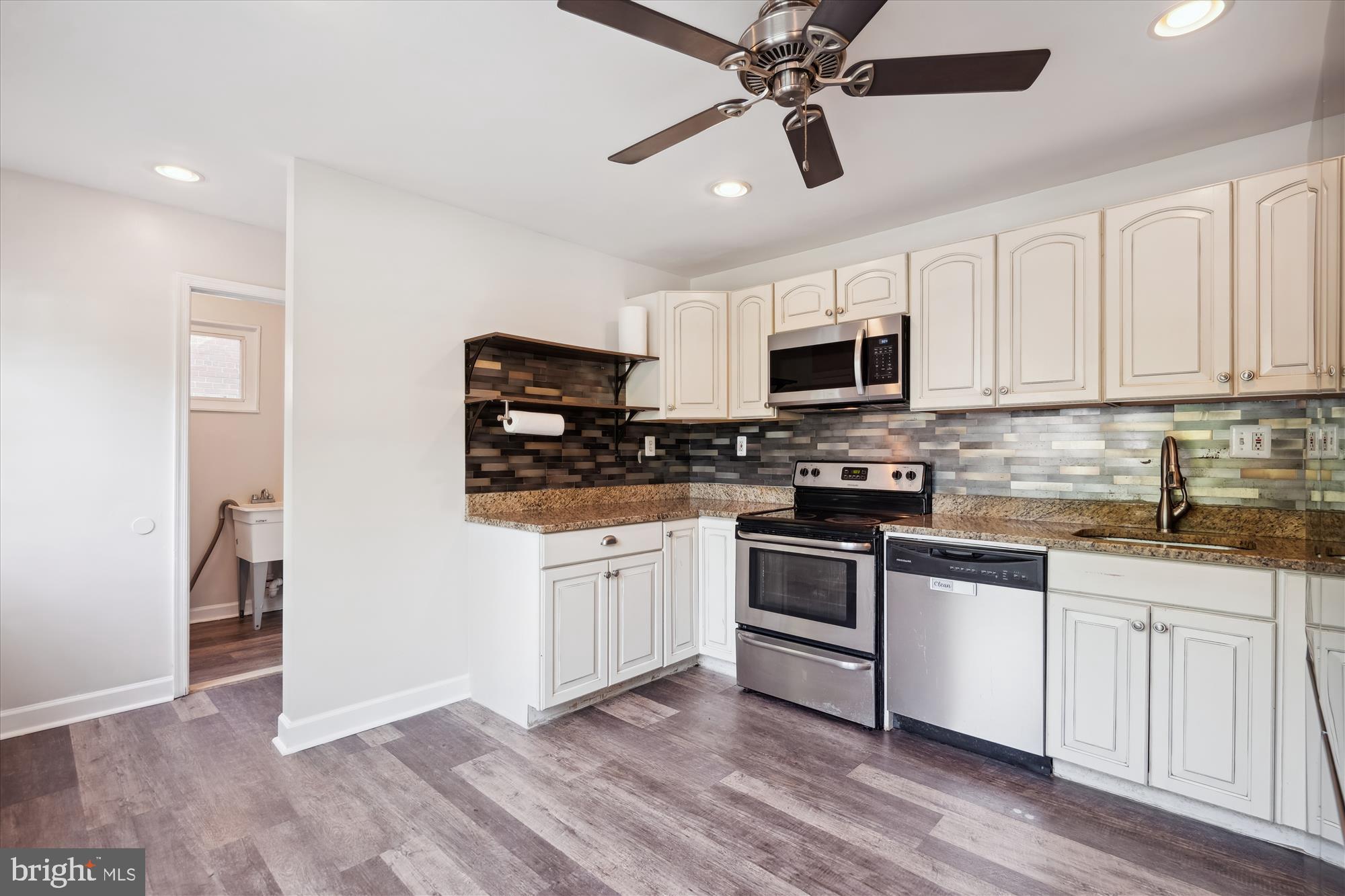 12812 Crisfield Road Silver Spring, MD 20906 - Photo 21 of 83 a kitchen with stainless steel appliances granite countertop a stove top oven a sink and white cabinets