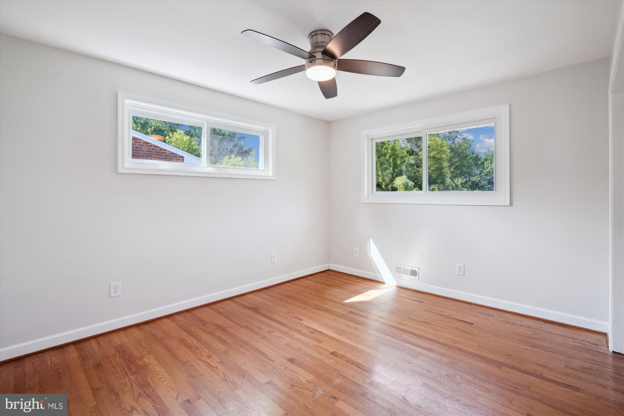 12812 Crisfield Road Silver Spring, MD 20906 - Photo 46 of 83 a view of an empty room with wooden floor and a ceiling fan