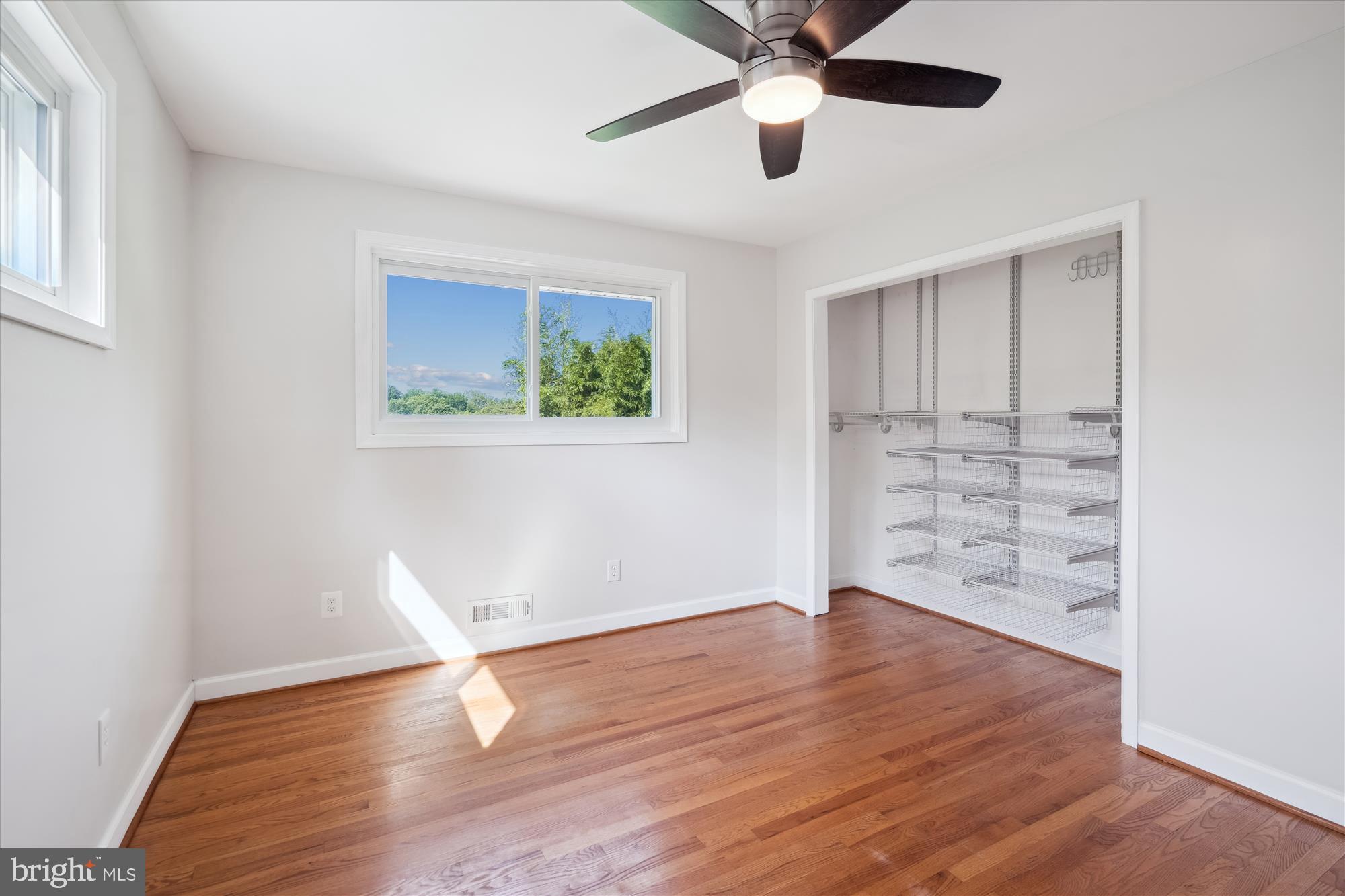 12812 Crisfield Road Silver Spring, MD 20906 - Photo 47 of 83 an empty room with wooden floor chandelier fan and windows