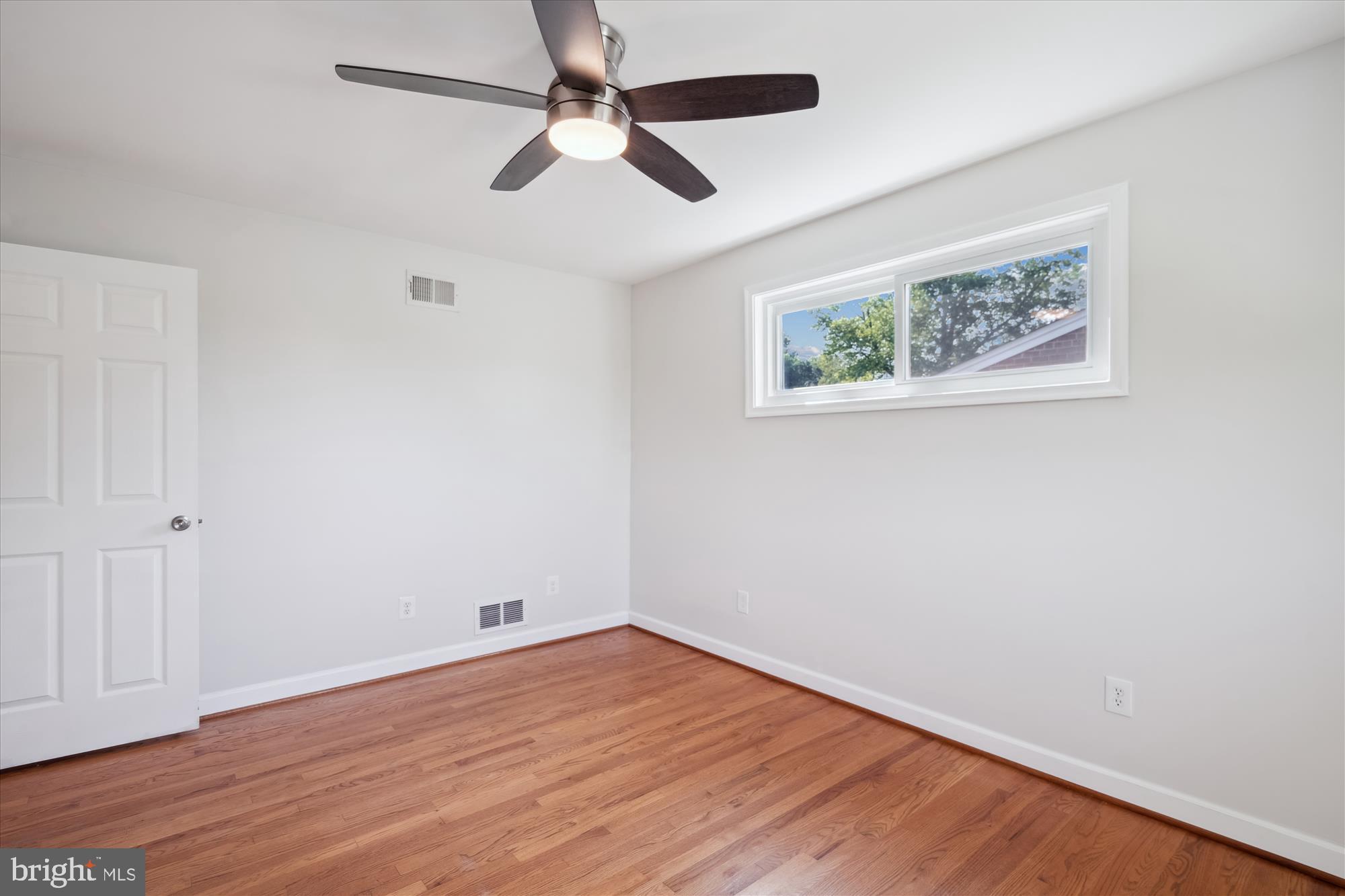 12812 Crisfield Road Silver Spring, MD 20906 - Photo 49 of 83 an empty room with wooden floor ceiling fan and window