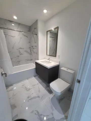 a bathroom with a sink a toilet a mirror and bathtub
