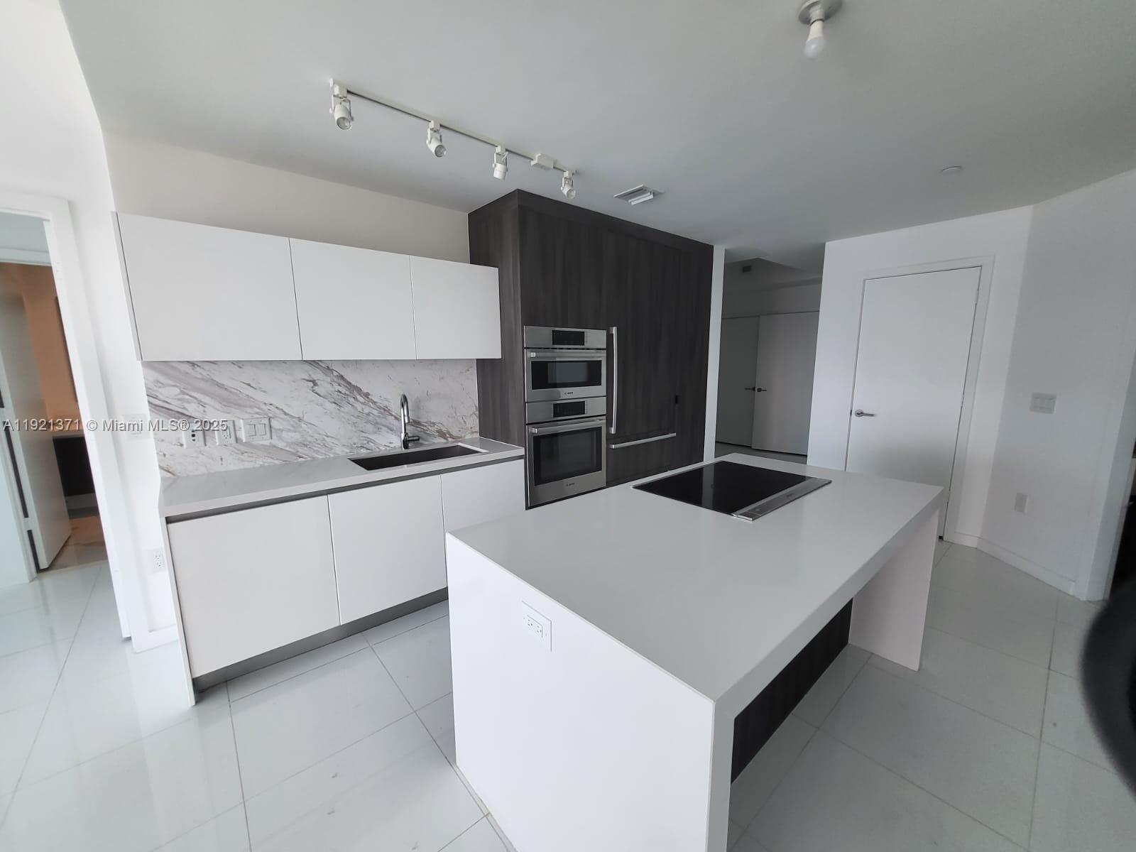 851 Northeast 1st Avenue, Unit 2008 Miami, FL 33132 - Photo 18 of 18 a kitchen with a stove a refrigerator and a sink