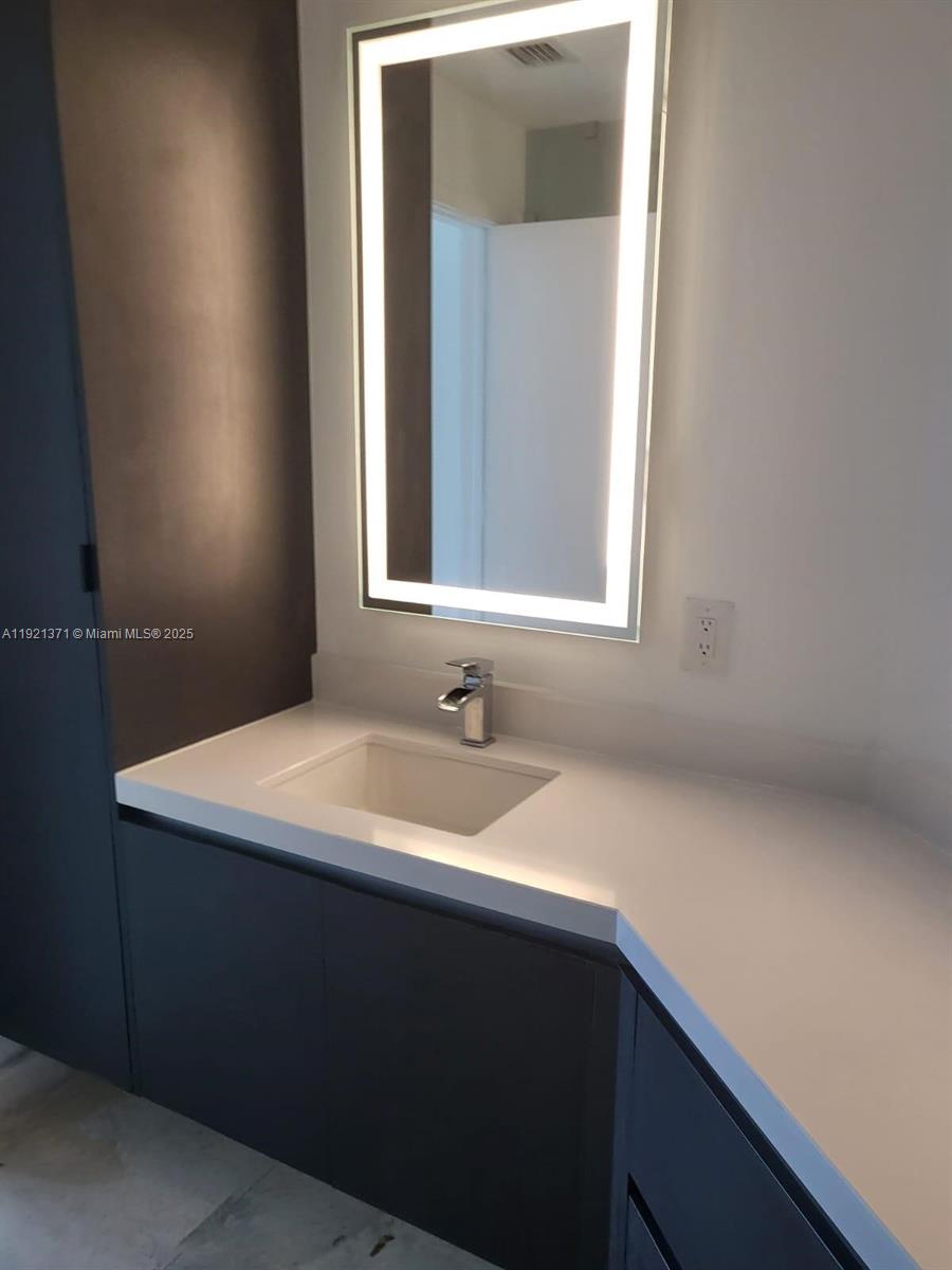 851 Northeast 1st Avenue, Unit 2008 Miami, FL 33132 - Photo 6 of 18 a bathroom with a sink and a mirror