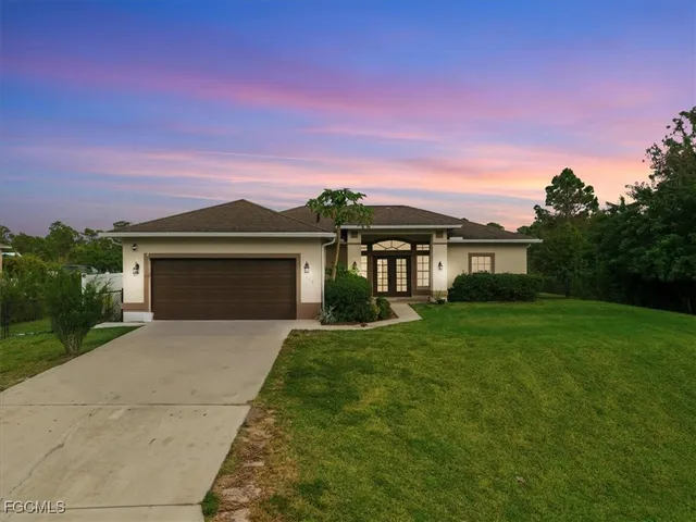 a front view of a house with a yard and garage