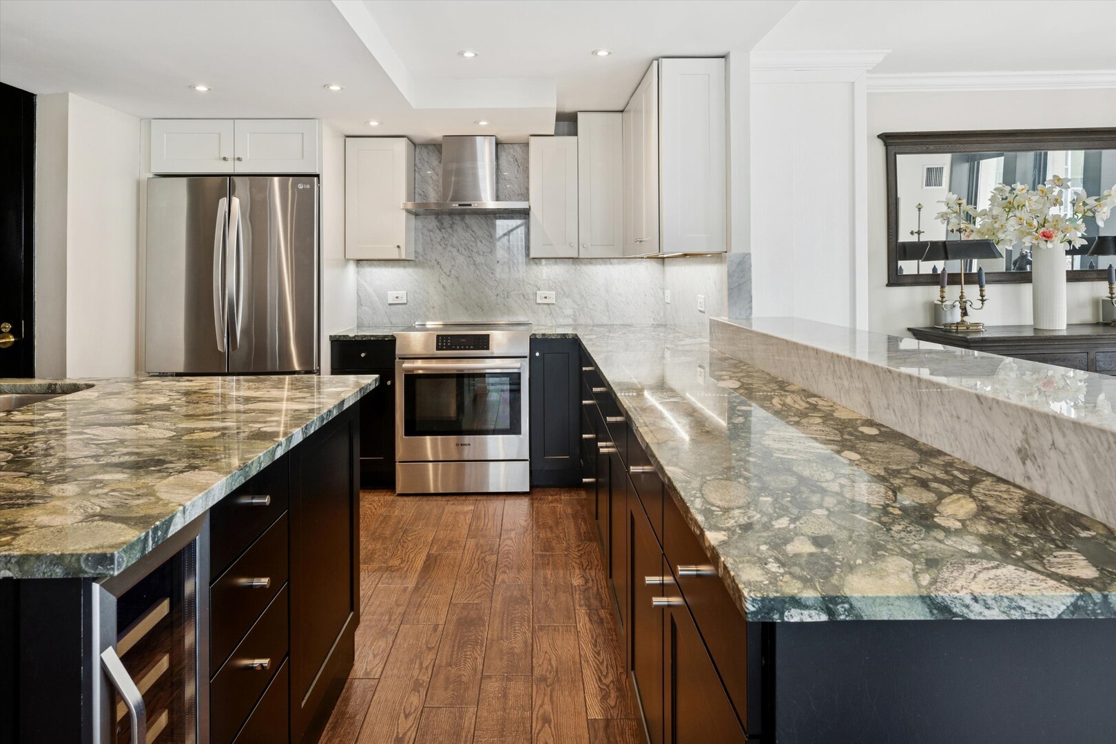 100 East Walton Street, Unit 41DE Chicago, IL 60611 - Photo 9 of 35 a kitchen with kitchen island granite countertop a sink stove and refrigerator