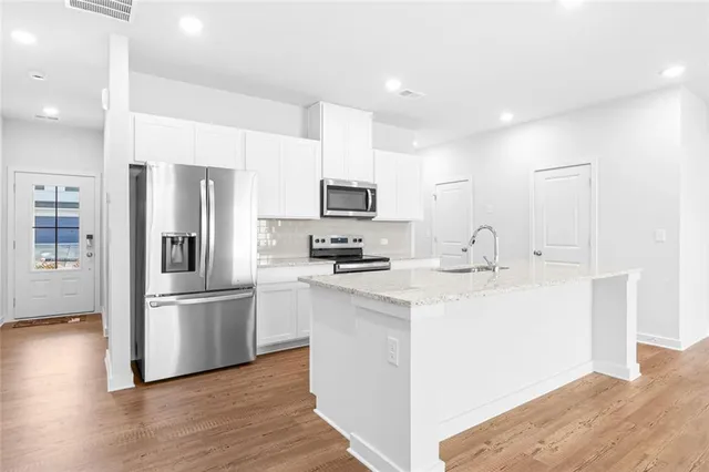 a kitchen with stainless steel appliances a refrigerator sink and microwave