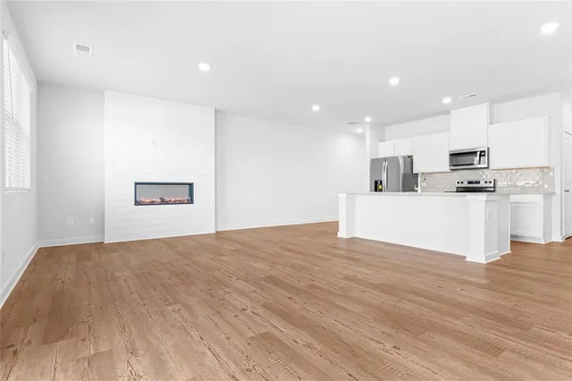 a view of kitchen with wooden floor and electronic appliances