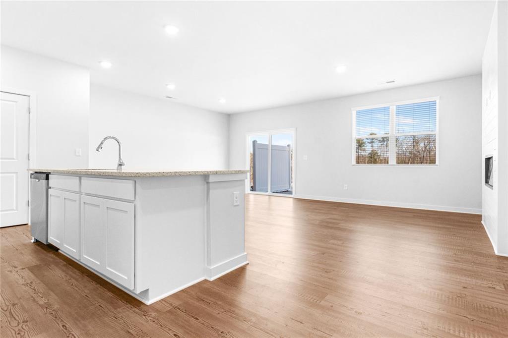 1925 Westwind Street Lawrenceville, GA 30043 - Photo 10 of 27 a kitchen with stainless steel appliances granite countertop a dishwasher a stove a refrigerator with white cabinets and wooden floor