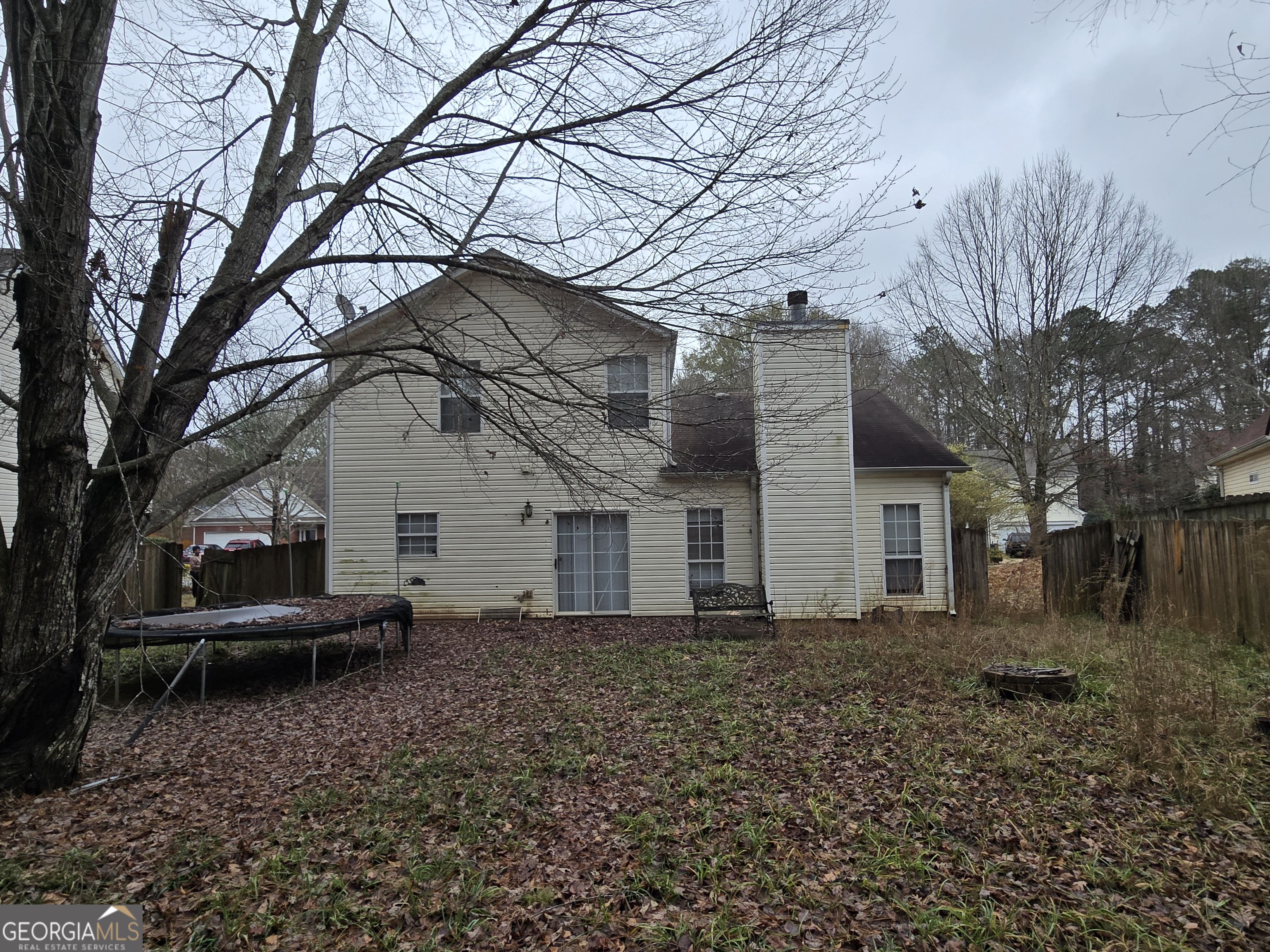 1558 Silver Ridge Drive Southwest Austell, GA 30106 - Photo 2 of 18 a backyard of a house with large trees and brick walls
