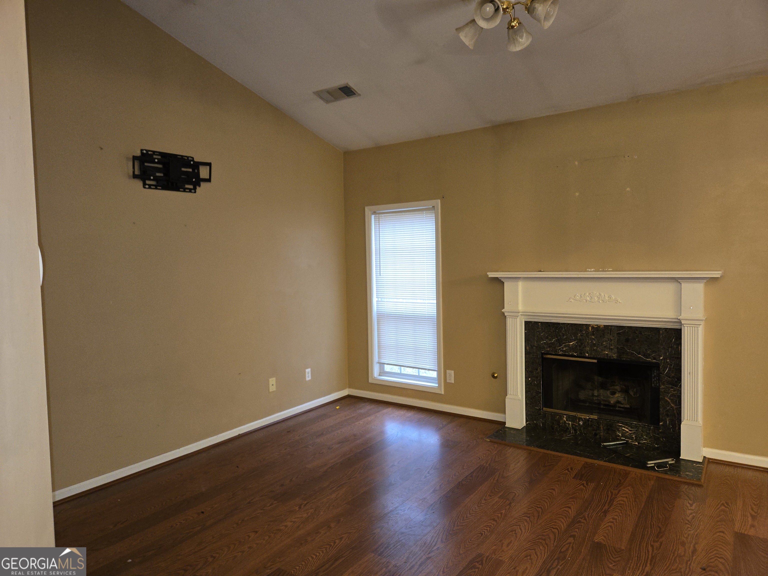 1558 Silver Ridge Drive Southwest Austell, GA 30106 - Photo 6 of 18 an empty room with wooden floor a fireplace and windows