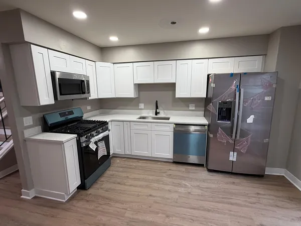 a kitchen with a stove a refrigerator and a microwave