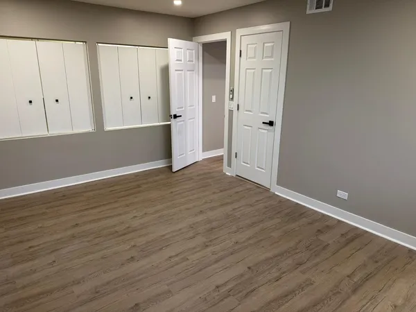 a view of an empty room with wooden floor