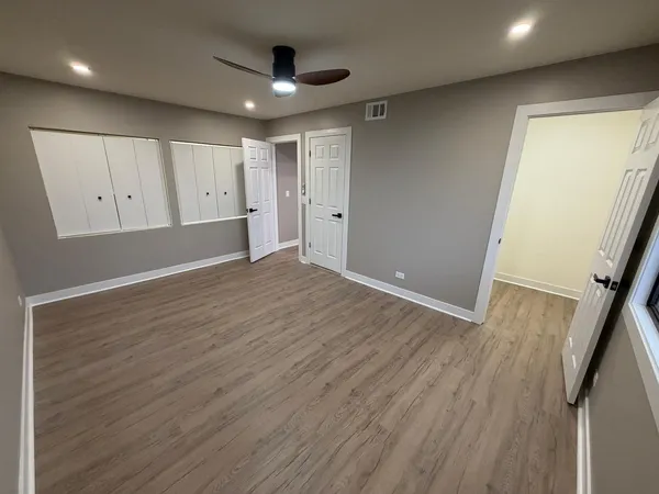 a view of empty room with wooden floor