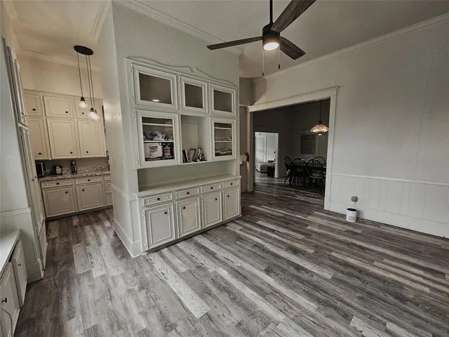 a room with a dresser and chandelier