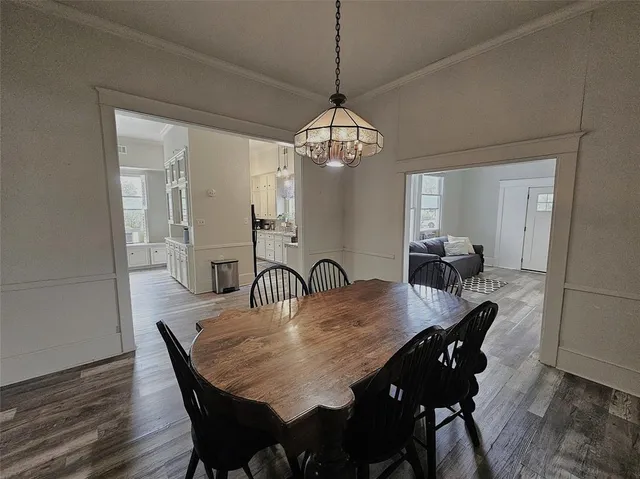 a view of a dining room and livingroom with furniture wooden floor a chandelier