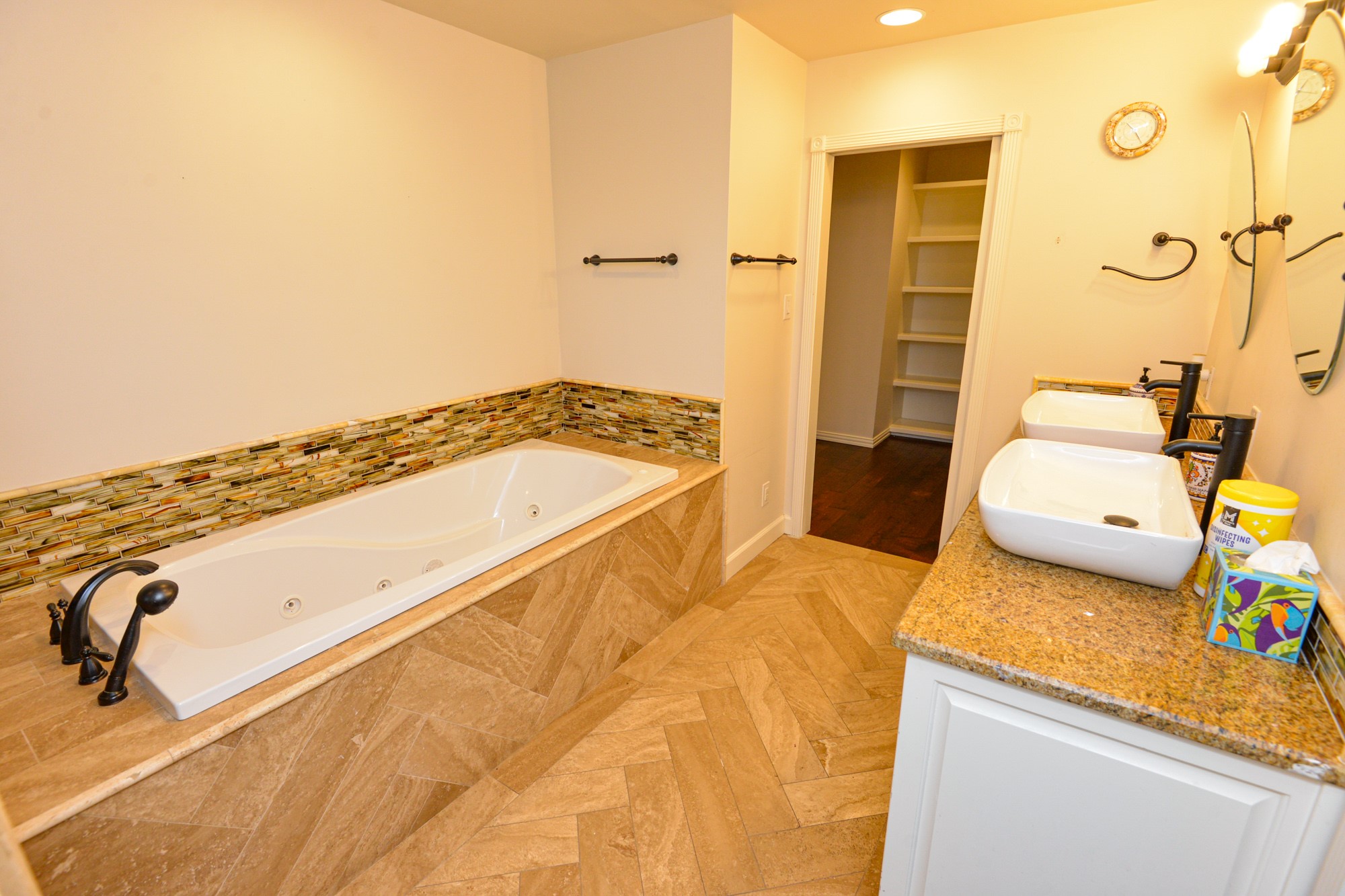10710 D-K Ranch Road Austin, TX 78759 - Photo 21 of 34 Indulge in a relaxing soak in the deep tub, featuring elegant tile surround and chevron-patterned flooring.