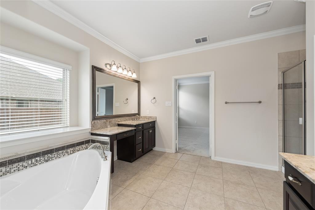 12571 Valley Spring Drive Frisco, TX 75035 - Photo 23 of 39 a spacious bathroom with a granite countertop tub sink and mirror