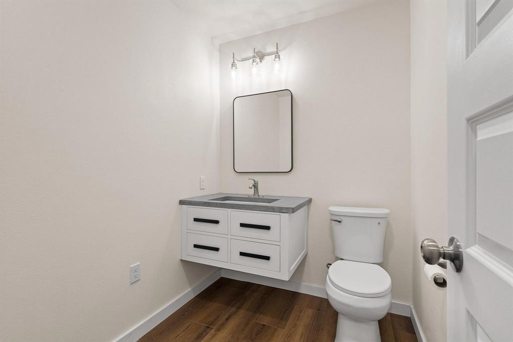 1325 Reynolds Road Whitewright, TX 75491 - Photo 16 of 39 a bathroom with a toilet a sink and mirror