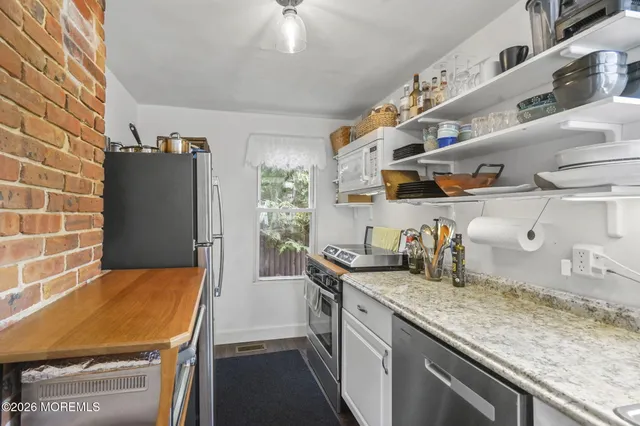 a kitchen with cabinets and wooden floor