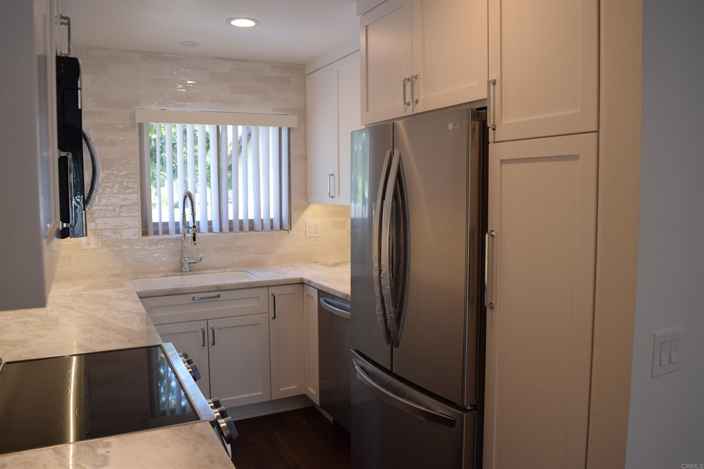 1723 Kellington Place Encinitas, CA 92024 - Photo 6 of 23 a kitchen with stainless steel appliances a refrigerator sink and cabinets