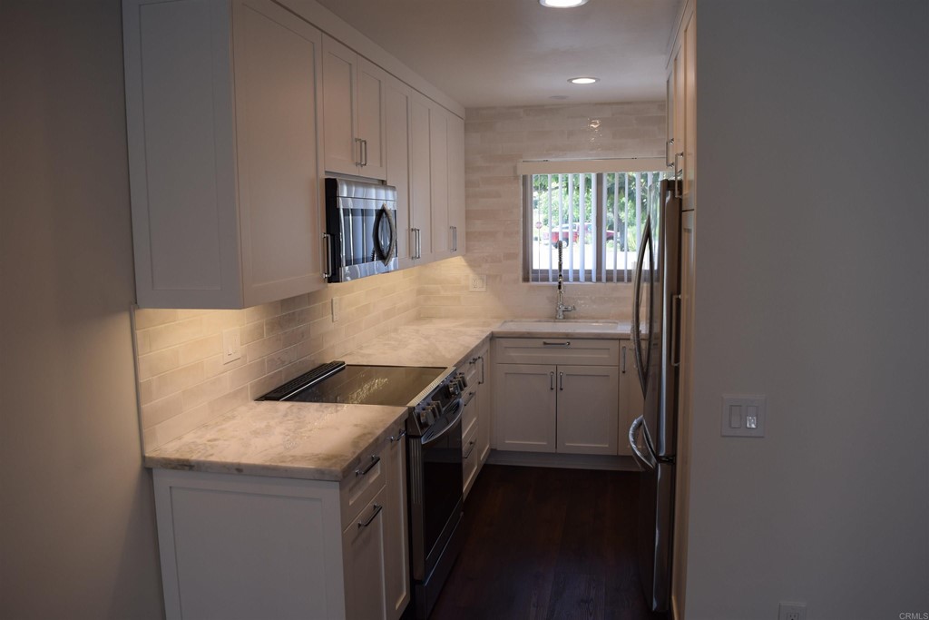 1723 Kellington Place Encinitas, CA 92024 - Photo 9 of 23 a kitchen with a sink and a refrigerator