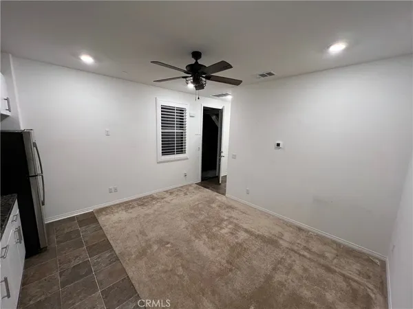 en empty room with windows and a ceiling fan