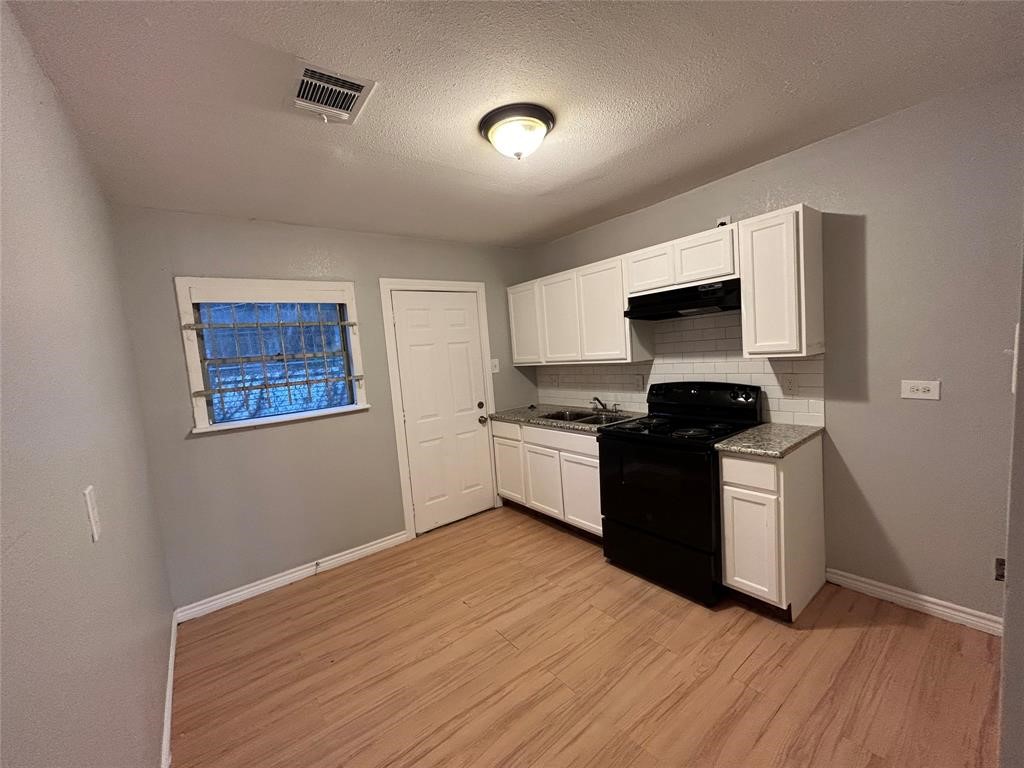 6818 Weston Street, Unit 1 Houston, TX 77021 - Photo 4 of 10 a kitchen with granite countertop a sink cabinets and stainless steel appliances