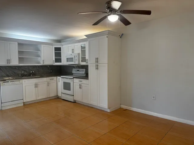 a kitchen with granite countertop a sink cabinets stainless steel appliances and a window