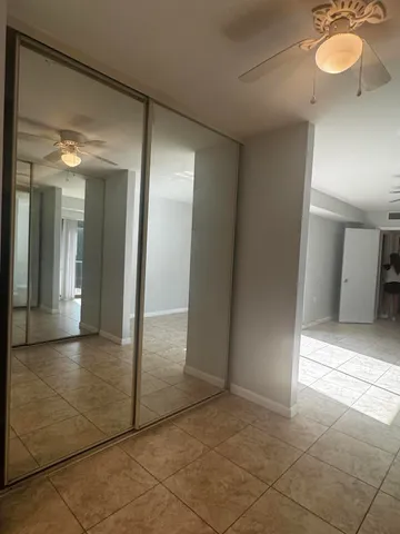 a tennis court that has a lots of trees in the background