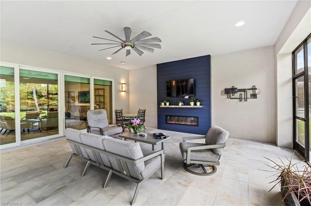 12033 Azalea Way Naples, FL 34120 - Photo 29 of 46 exterior patio features beautiful fireplace accent wall and 12 blade fan for maximum air movement