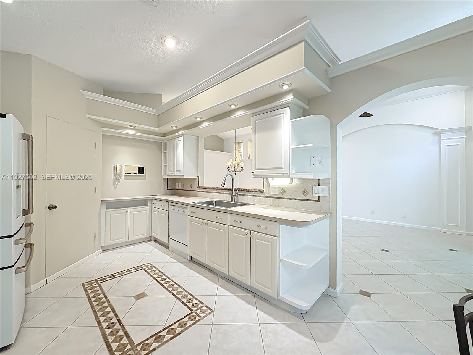 356 Hammocks Trail Greenacres, FL 33413 - Photo 12 of 41 a large white kitchen with a sink and dishwasher a refrigerator with white cabinets