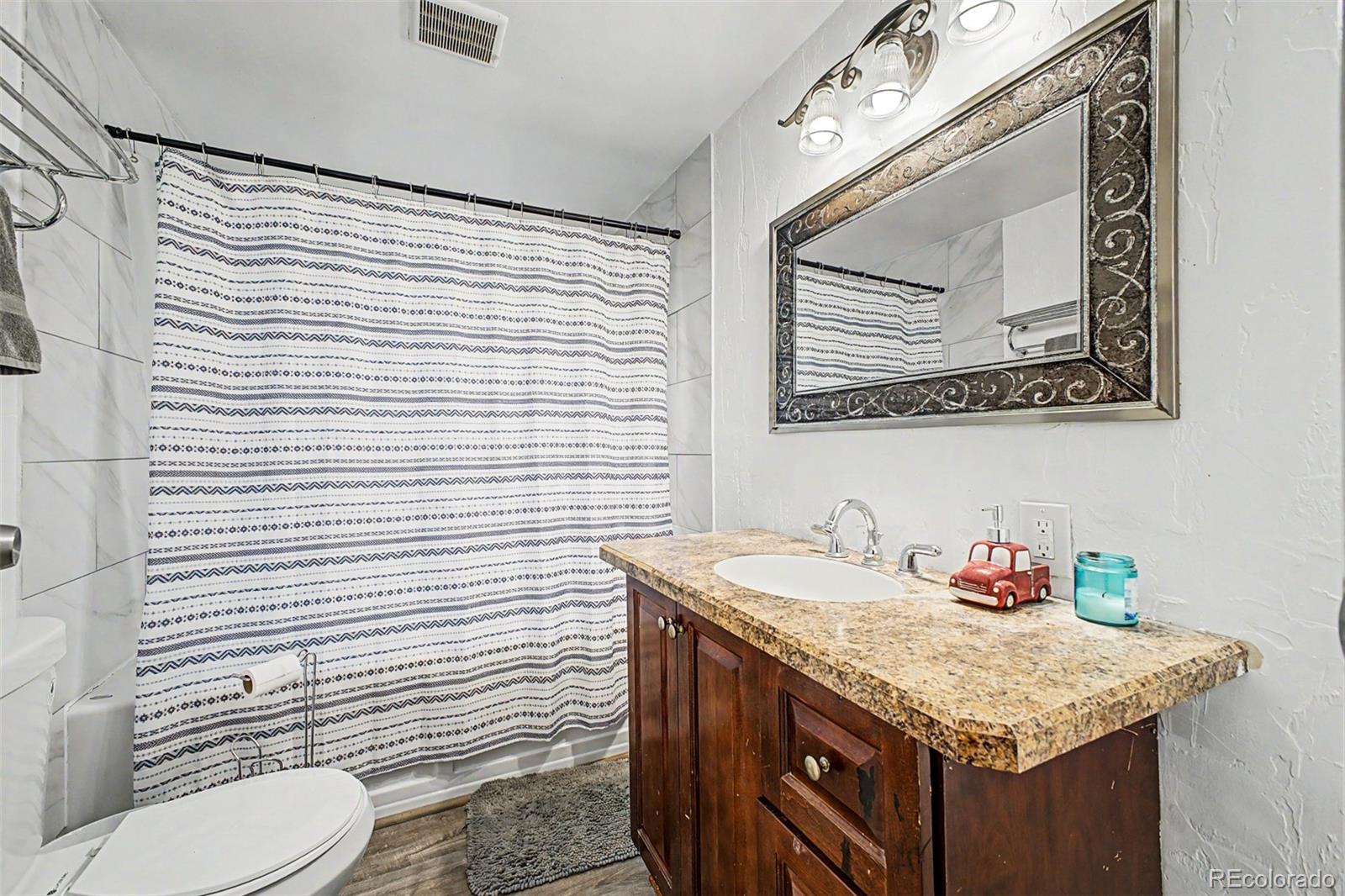 145 Bailey Drive Bailey, CO 80421 - Photo 22 of 31 a bathroom with a granite countertop sink vanity mirror and toilet