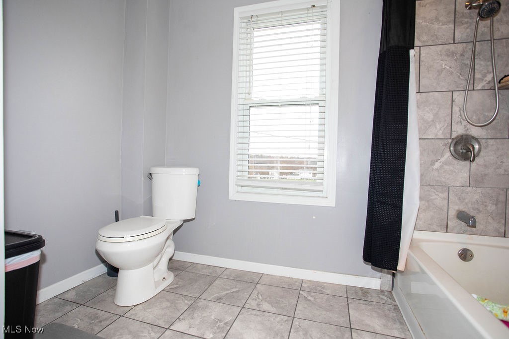 125 Ridgeway Street Struthers, OH 44471 - Photo 18 of 24 Bathroom featuring toilet, tile patterned floors, shower / tub combo with curtain, and plenty of natural light