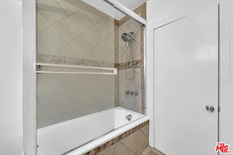 a view of an empty room with wooden floor and a ceiling fan